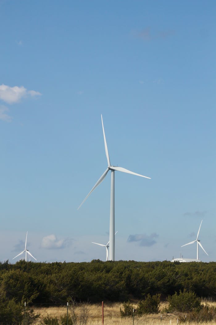 The Art of Drawing Readers In: Your attractive post title goes here Wind farm with towering turbines set against a clear blue sky. Renewable energy in rural landscape.