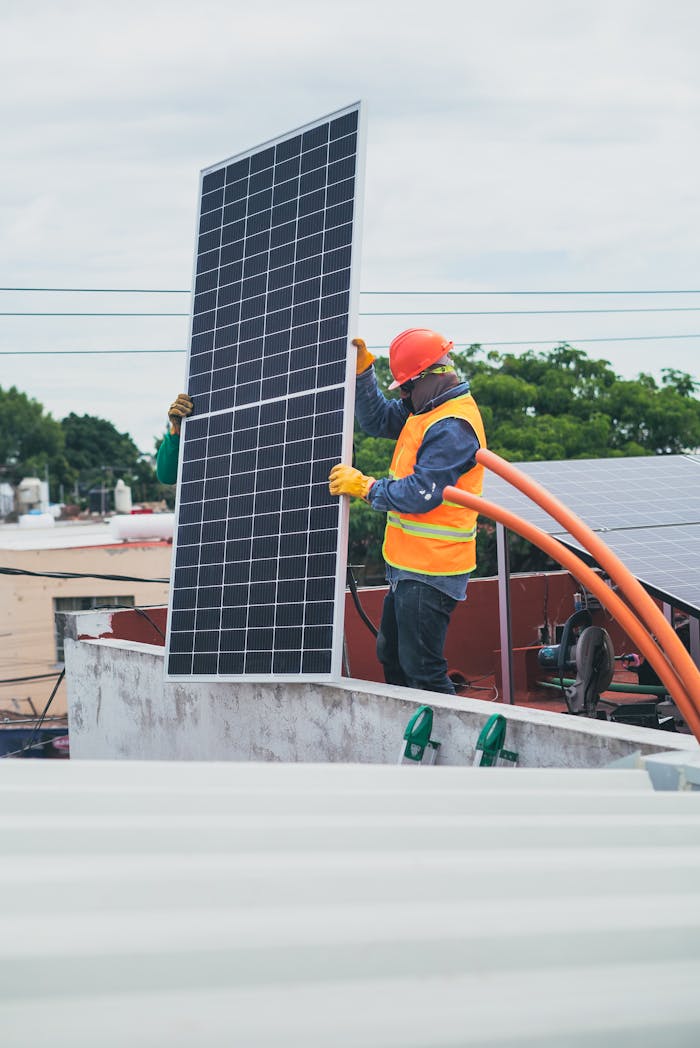 about-us A technician in safety gear installs a solar panel on a rooftop, promoting renewable energy.
